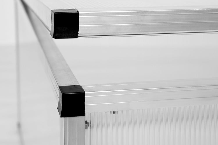Nahaufnahme der Aluminiumprofile und schwarzen Kunststoff-Eckverbinder eines Frühbeets.