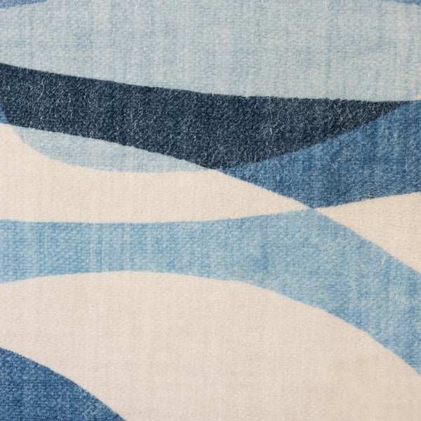 Detailansicht eines Teppichs mit abstraktem Wellenmuster in Blau und Creme.