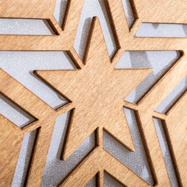 Dekorativer Holzstern mit Aussparungen und glitzernder Oberfläche