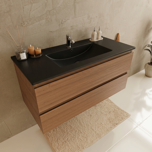 Moderner, wandhängender Waschplatz mit schwarzem Waschbecken und Holzunterschrank mit zwei Schubladen in einem hellen Badezimmer.