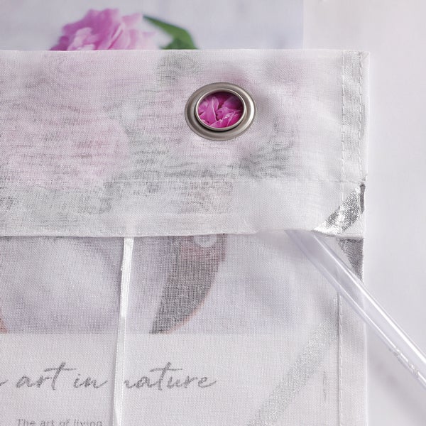 Detailaufnahme eines Vorhangs mit Blumenmuster und Ösenaufhängung