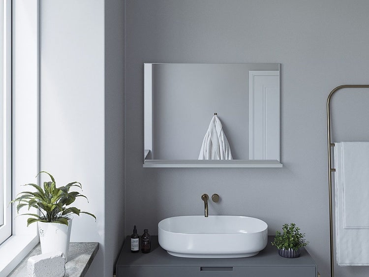 Badezimmerspiegel mit Ablage über einem Aufsatzwaschbecken und Unterschrank in einem modernen, hellen Badezimmer mit Handtuchhalter.