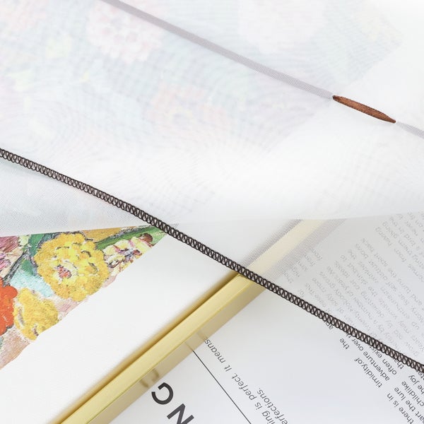 Detailaufnahme eines Dekostoffs mit Blumenmuster und goldenem Rahmen