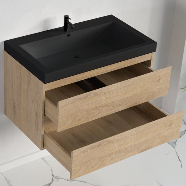 Wandhängender Waschtischunterschrank in Holzoptik mit matt schwarzem Waschbecken und Armatur sowie zwei geöffneten Schubladen.