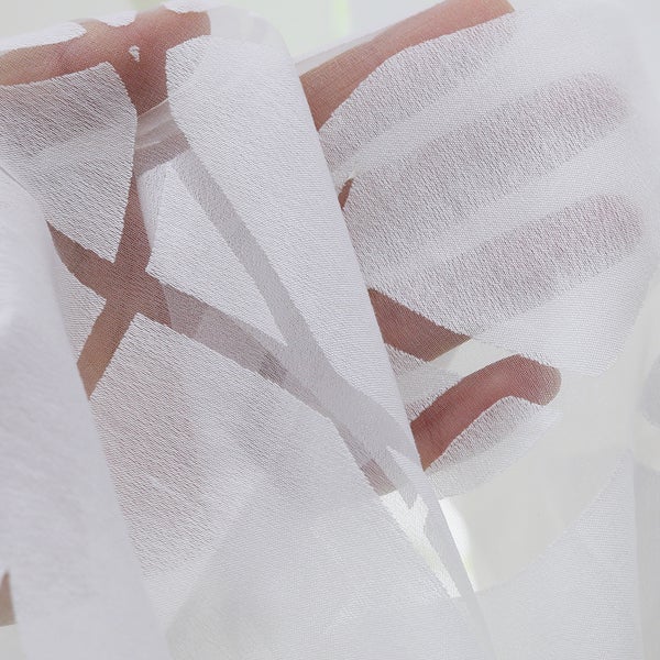 Detailaufnahme eines weißen, transparenten Vorhangs mit Muster