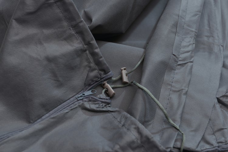 Detailansicht einer wetterfesten Abdeckhaube aus robustem Gewebe mit Reißverschluss und Kordelzug zum Fixieren.