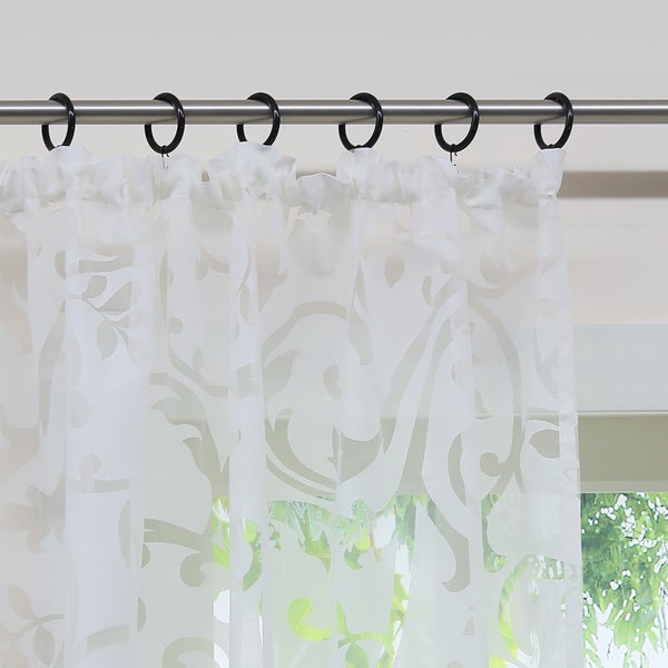 Gardine mit Muster an einer Gardinenstange mit Ringen