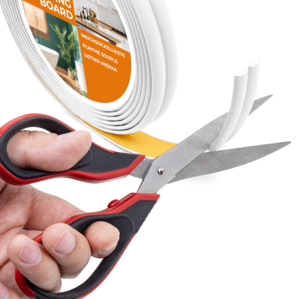 Eine Rolle weiche Sockelleiste wird mit einer Schere zugeschnitten.