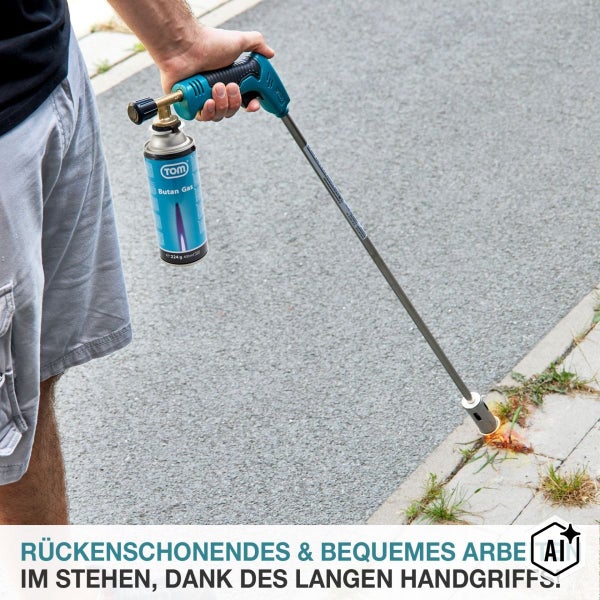 Ein Unkrautbrenner mit langer Lanze und Gaskartusche bei der Anwendung auf einem Pflasterweg.