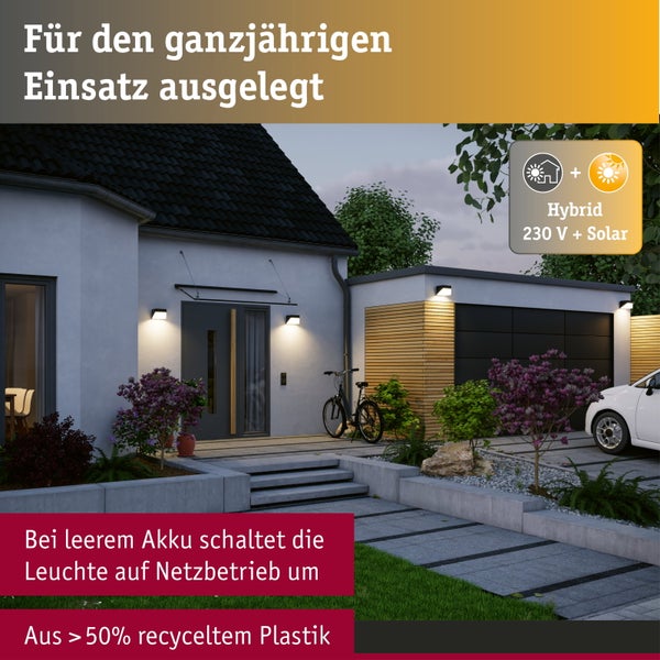 Moderne Außenwandleuchten an einem Haus mit Garage bei Dämmerung, Hybrid-Betrieb mit Solar und 230 Volt Netzstrom.