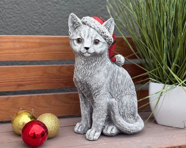 Dekorative Katzenfigur aus Stein in weihnachtlicher Optik mit Nikolausmütze als Garten- oder Zimmerdekoration.