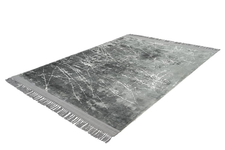Grauer rechteckiger Teppich mit abstraktem Marmormuster, feinen weißen Linien und Fransen.