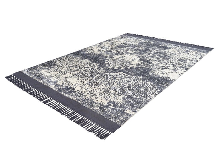Rechteckiger Teppich mit abstraktem Vintage-Muster und Fransen an den Enden.