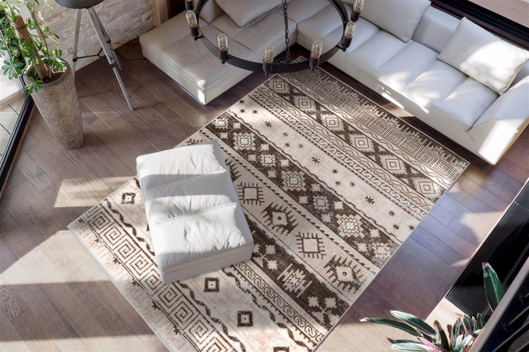 Teppich mit geometrischem Ethno-Muster in einem modernen Wohnzimmer mit hellem Sofa und Holzfußboden.