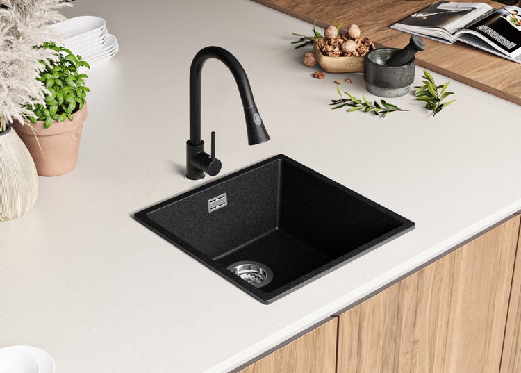 Schwarzes Küchenspülbecken mit Wasserhahn auf einer Arbeitsplatte