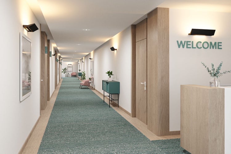 Moderner Hotelflur mit hellem Interieur, Teppichboden, Holztüren und dezenter Wandbeleuchtung für eine einladende Atmosphäre.