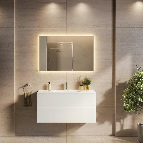 Modernes Badezimmer mit weißem Waschtischunterschrank, beleuchtetem Wandspiegel und beigen Fliesen für eine wohnliche Atmosphäre.