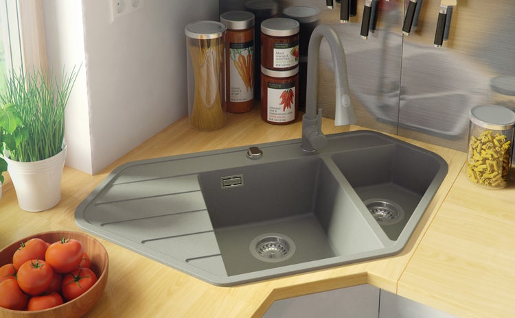 Eckspüle aus Granit mit zwei Becken und Abtropffläche in einer hellen Küche
