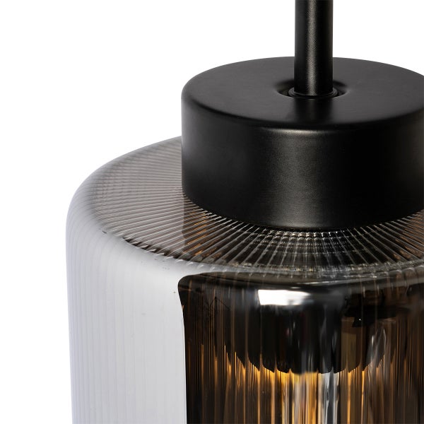 Detailaufnahme einer Pendelleuchte mit geriffeltem Glasschirm und schwarzer Aufhängung.