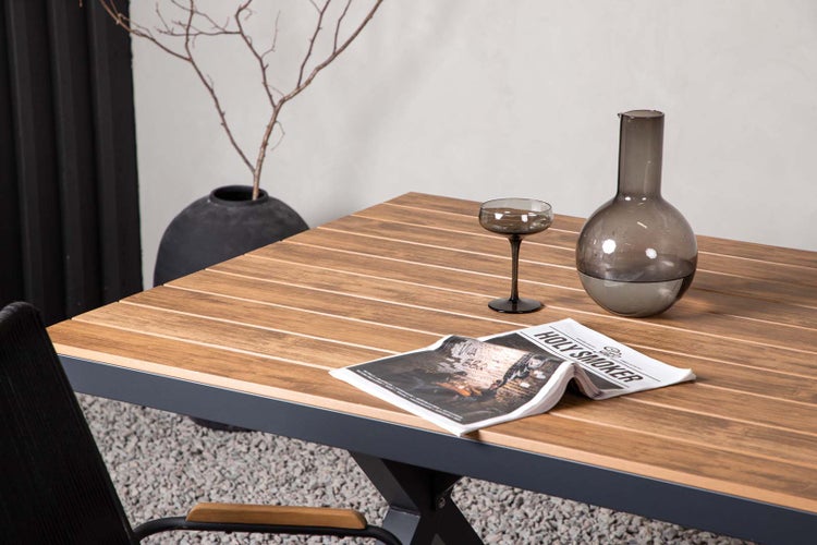 Nahaufnahme eines Tisches mit Dekorationsgegenständen, darunter eine Vase, ein Glas und eine Zeitschrift.