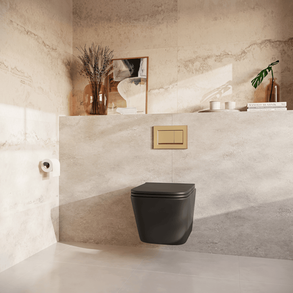 Modernes Badezimmer mit wandhängendem WC, goldener Betätigungsplatte und hellen Steinfliesen, harmonisch eingerichtet mit Deko-Objekten.