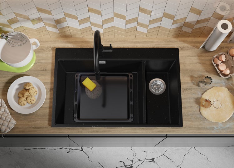 Spüle mit Armatur, Backblech, Spülschwamm und Küchenutensilien auf einer Küchentheke