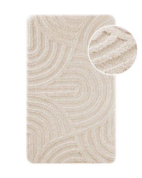 Rechteckige Badematte aus weichem Textil mit strukturiertem Wellenmuster in Beige.