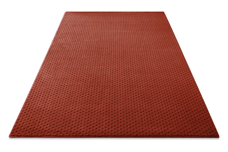 Roter, rechteckiger Teppich mit feinem, dunklem Punktmuster und strukturierter Oberfläche.