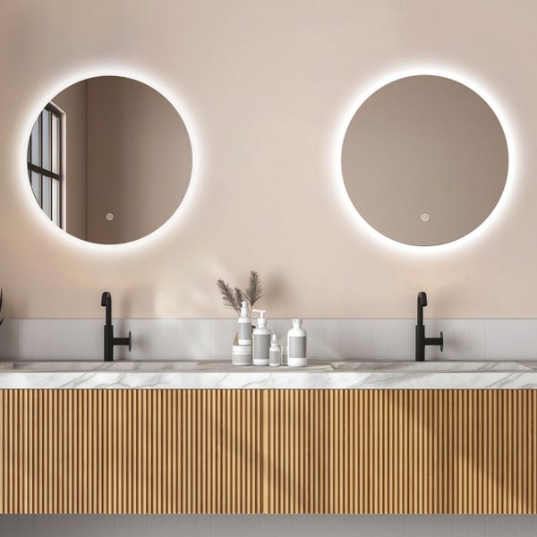 Badezimmer mit Doppelwaschtisch, Unterschrank aus Holzlamellen und zwei runden LED Spiegeln mit integriertem Touchschalter.