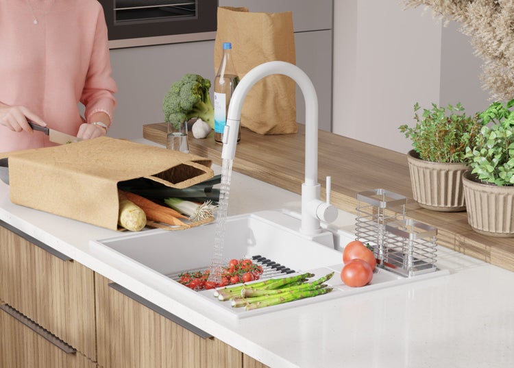 Küchenszene mit Spüle, Armatur, Gemüse und Person