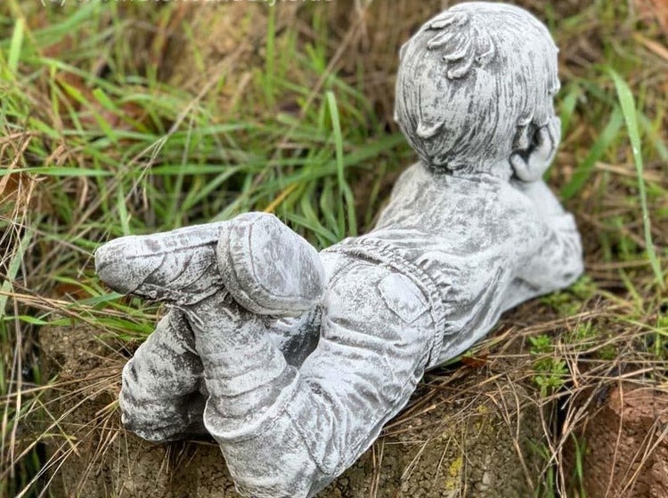 Gartenfigur in Form eines liegenden Jungen aus wetterfestem Steinguss zur Dekoration im Garten oder auf der Terrasse.