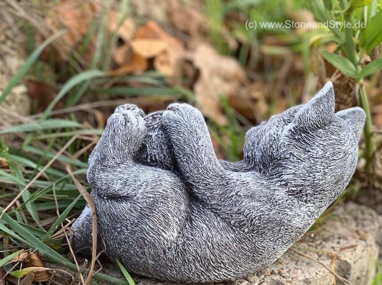 Steinfigur einer liegenden Katze als Dekoration für den Garten aus wetterfestem Material.