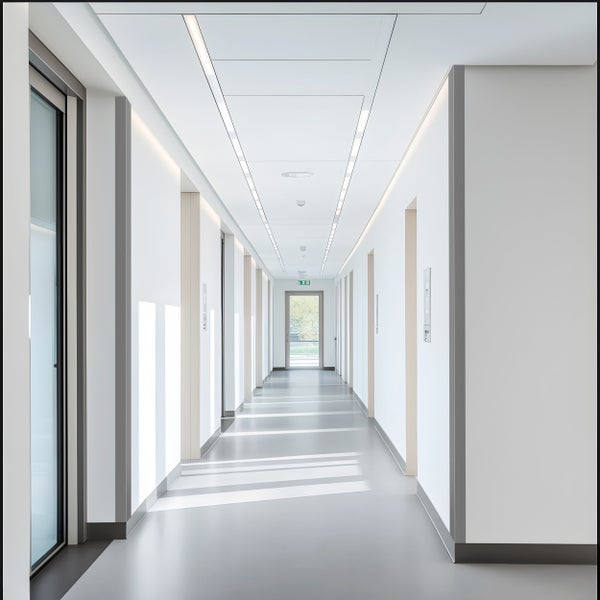 Heller Flur mit linearen Leuchten und Türen