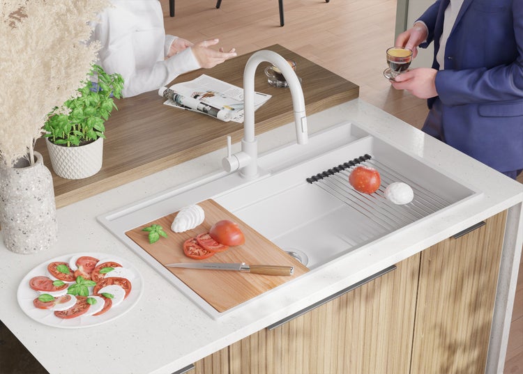 Küchenspüle mit Abtropfgestell, Schneidebrett und Armatur in einer hellen Küche