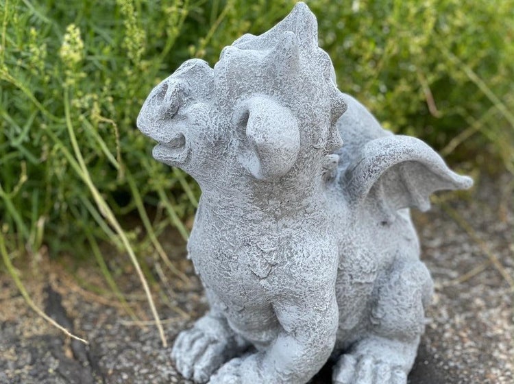 Dekorative Gartenfigur aus Stein in Form eines kleinen sitzenden Drachen.