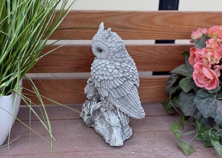 Detailreiche Gartenfigur einer Eule aus Steinguss, auf einem Ast sitzend, dekorative Gartenfigur für den Außenbereich.