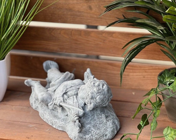 Steinfigur Engel mit Geige, Dekofigur für den Garten aus Steinguss, liegender Engel als Garten-Deko, wetterfeste Skulptur für den Außenbereich.