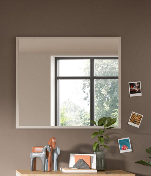 Rechteckiger Spiegel an einer Wand über einem Tisch