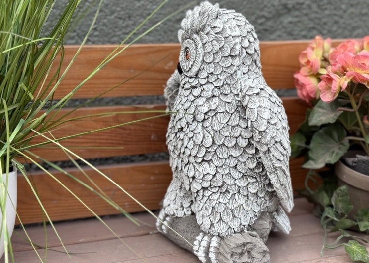 Detaillierte Eulen Gartenfigur aus Steinguss in Steinoptik auf einem Ast sitzend als dekoratives Element für den Außenbereich.