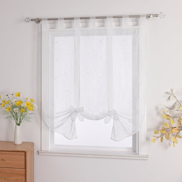 Gardine mit Bindebändern am Fenster