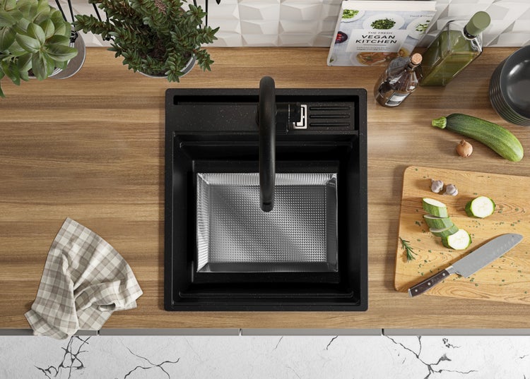 Küchenspüle mit Abtropffläche, Armatur, Schneidebrett, Messer und Lebensmitteln auf einer Arbeitsplatte