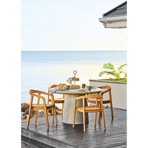 Essgruppe mit Holzsesseln und rundem Tisch im Freien