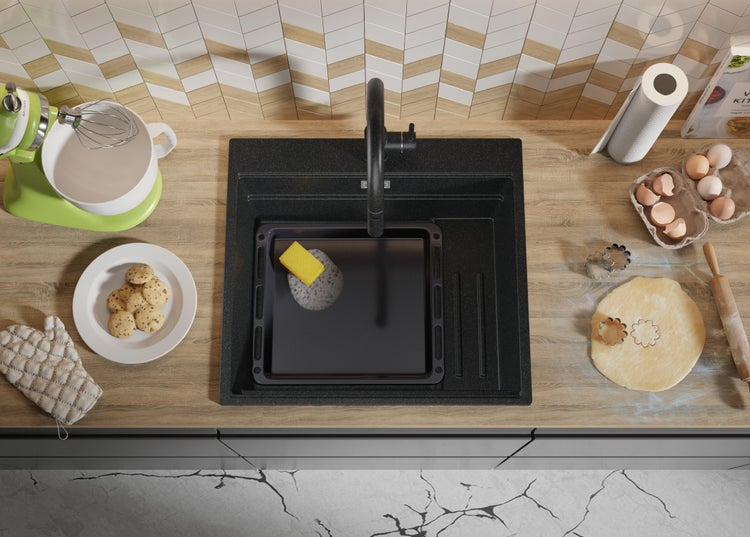 Küchenspüle mit Backblech, Spülschwamm und Küchenutensilien auf einer Küchentheke