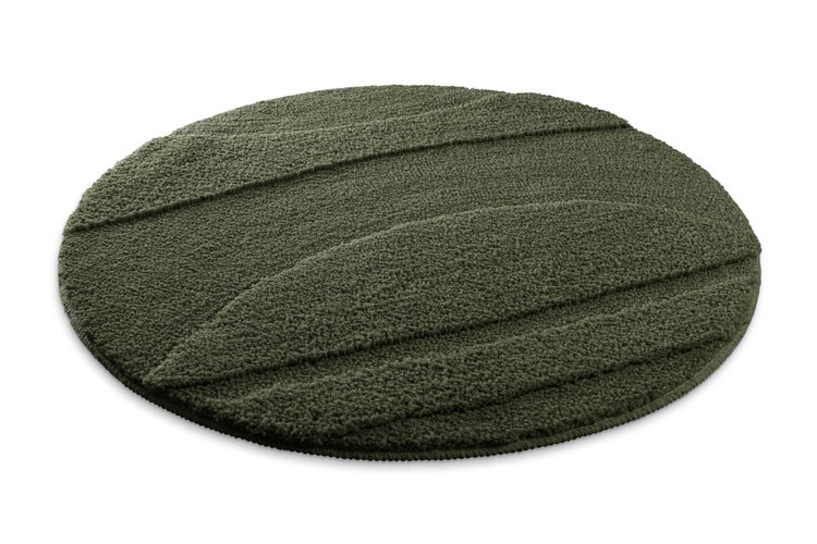 Runder, grüner Badeteppich mit geprägter Wellenstruktur aus weichem Material.