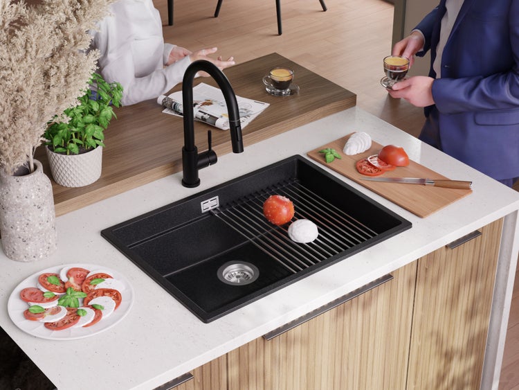 Schwarzes Spülbecken mit Abtropfgitter in einer hellen Küche