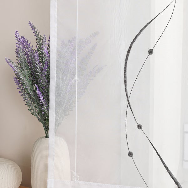 Dekoratives Fenster mit Stickerei und Blumenvase