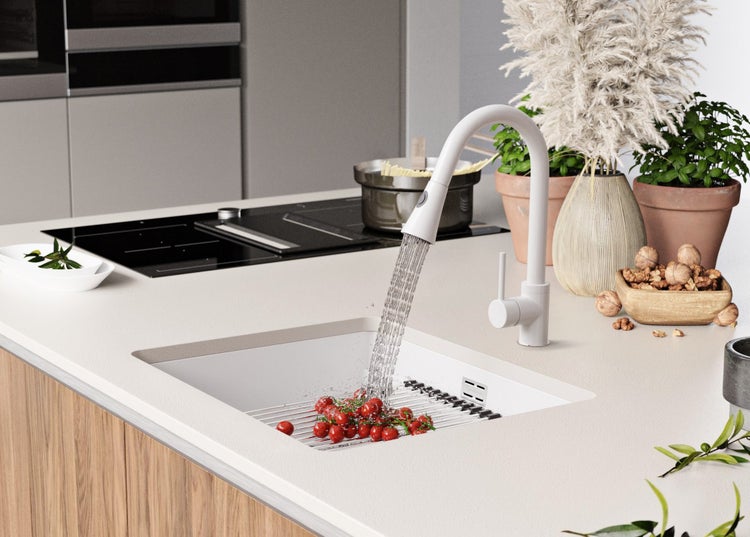 Küchenszene mit Spüle, Armatur und Lebensmitteln auf der Arbeitsplatte.