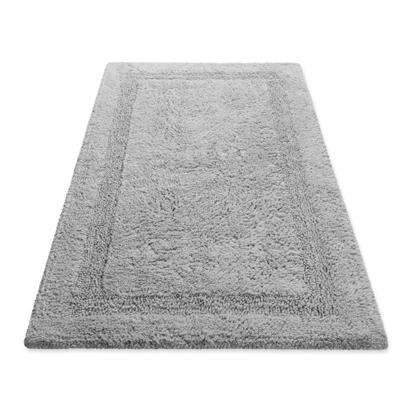 Grauer Badeteppich aus weichem Material mit strukturierter Bordüre, rechteckig.