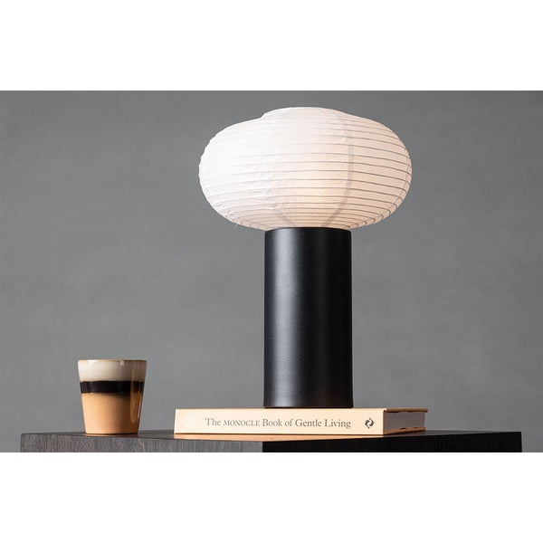 Tischleuchte mit schwarzem Sockel und weißem Lampenschirm