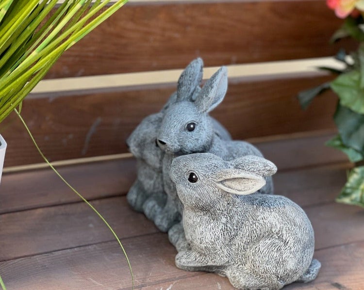 Zwei sitzende Gartenhasen Figuren aus Stein für die Außendekoration.